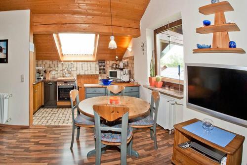 a kitchen and dining room with a table and a television at Ferienwohnung Promenadenweg Nesselwang 14-8 in Nesselwang