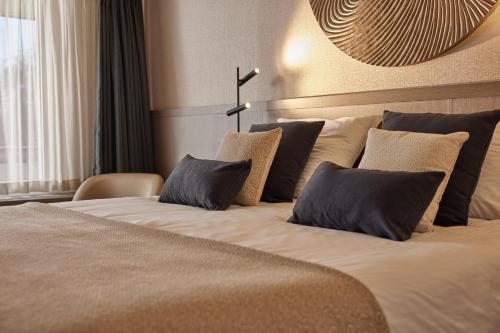 a bedroom with a large bed with pillows at Thermen Bad Nieuweschans in Bad-Nieuweschans