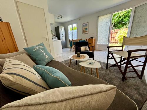 un salon avec un canapé et une table dans l'établissement Le Cocon Salé - 5 min à pieds des plages - jardin, à Guidel