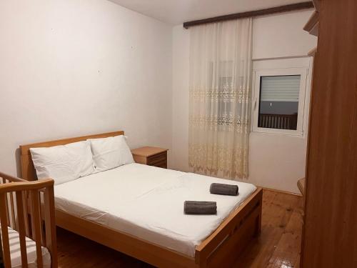 una piccola camera da letto con un letto e una finestra di Duraku Apartment a Ulcinj