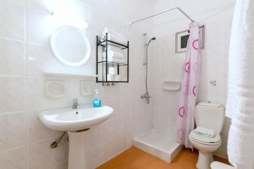 a white bathroom with a sink and a toilet at Ni-Mar Studios & Apartments in Lithakia
