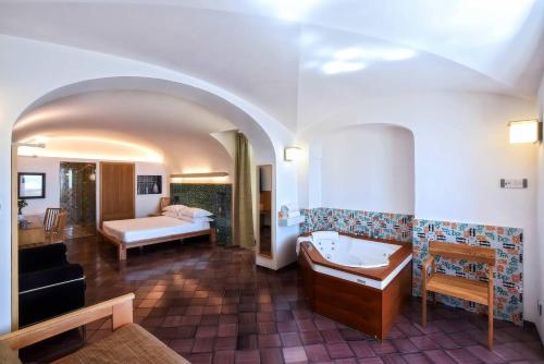a room with a bathroom with a tub and a bedroom at La Moresca in Ravello