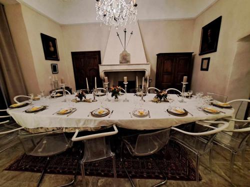 a dining room with a table with chairs and a chandelier at Chateau de Sainte Jalle in Sainte-Jalle