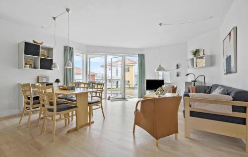 Una sala de estar con una mesa y un comedor. en Gudhjem Søpark Lejl 15, en Gudhjem