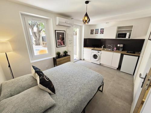 un salon avec un lit et une cuisine dans l'établissement Gregbnb - Studio 17m2 - Terrasse - Clim - Ouest - 5, à Toulon