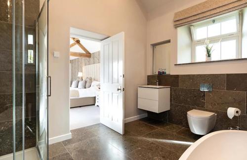 a bathroom with a shower and a bedroom at Beach Tree House in Gloucestershire