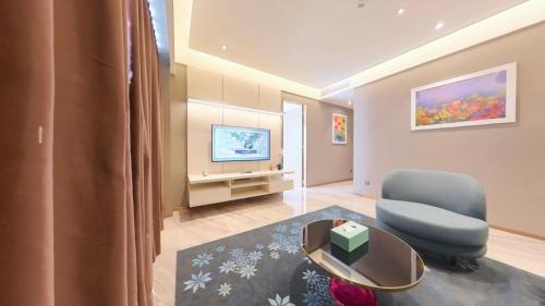 a living room with a blue chair and a television at Imperial KLCC Residence in Kuala Lumpur