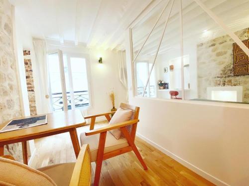 Il comprend un salon avec une table en bois et une cuisine. dans l'établissement Charmant appartement a Paris - FLAT-GUEST, à Paris