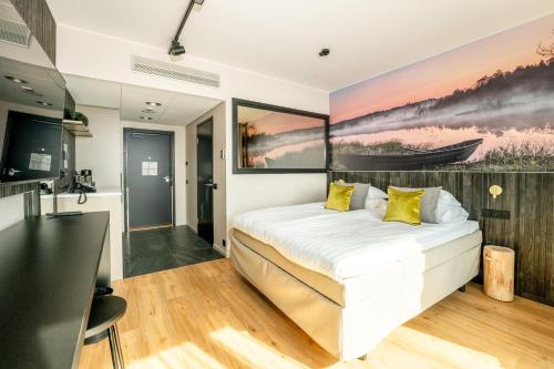 a bedroom with a bed with a painting on the wall at Break Sokos Hotel Bomba in Nurmes