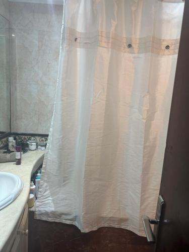 a bathroom with a shower with a white shower curtain at Charmant appartement in Casablanca