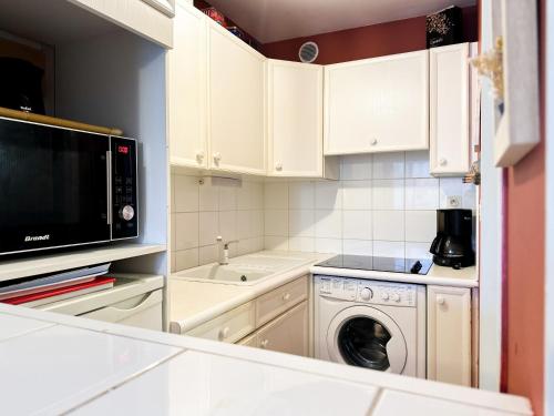 une cuisine avec un lave-linge et un micro-ondes dans l'établissement Appartement cœur de ville Les Sables - 4 personnes, à Les Sables-dʼOlonne
