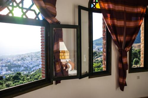 a window with a view of a city at Haven Hills Social Club in Chefchaouene