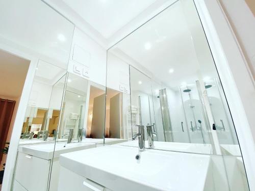 une salle de bain avec deux lavabos et un grand miroir dans l'établissement Appartement de standing a Paris - FLAT-GUEST, à Paris