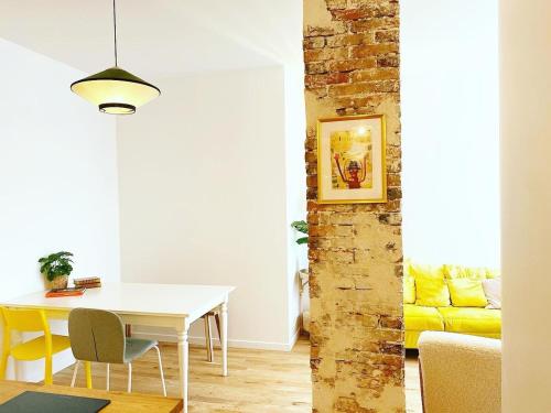 un salon avec une table et un canapé jaune dans l'établissement Sublime loft au coeur de Paris 10 - FLAT-GUEST, à Paris
