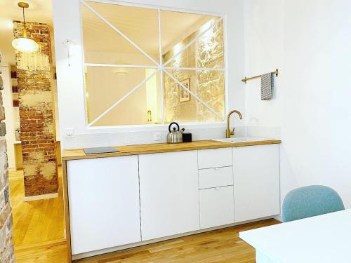 une cuisine avec un évier et une fenêtre dans l'établissement Sublime loft au coeur de Paris 10 - FLAT-GUEST, à Paris