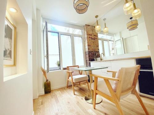 une cuisine avec une table et des chaises dans une pièce dans l'établissement Magnifique appartement a Paris - FLAT-GUEST, à Paris