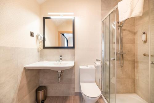 a bathroom with a toilet and a sink and a shower at Ignasiak Hotel in Września