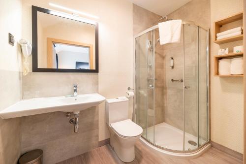 a bathroom with a toilet sink and a shower at Ignasiak Hotel in Września