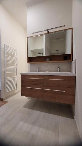 La salle de bains est pourvue d'un grand miroir et d'un lavabo. dans l'établissement La Pinède, logement privatif au château, à Aumes