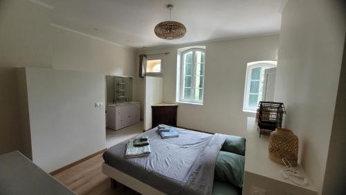 une chambre avec un lit et une télévision dans l'établissement La Pinède, logement privatif au château, à Aumes