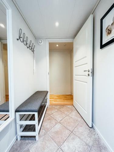 a hallway with a bench in front of a door at Bright and cozy studio - newly renovated bathroom and free parking in Høiset