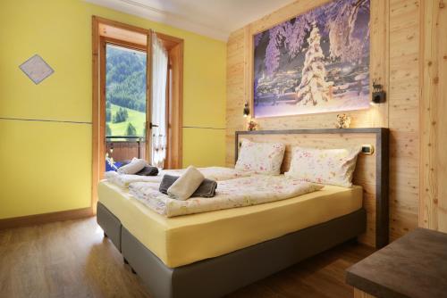 a bedroom with a bed with a painting on the wall at Baita La Fonte in Livigno