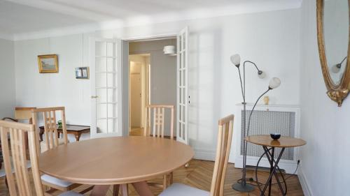 une salle à manger avec une table et des chaises en bois dans l'établissement Rue Yvon Villarceau - Paris 16, à Paris