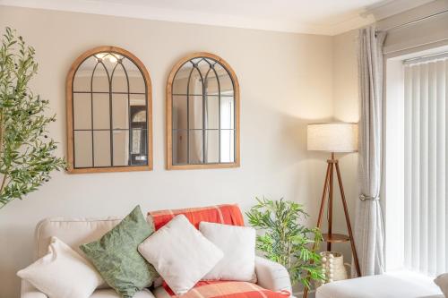 a living room with a couch and two mirrors at Pottery Place - Pet-friendly Huddersfield House Sleeps 7 in Huddersfield