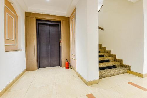 a hallway with a black door and stairs at Hotel Supreme - 700M From Vasco Da Gama Railway Station in Marmagao
