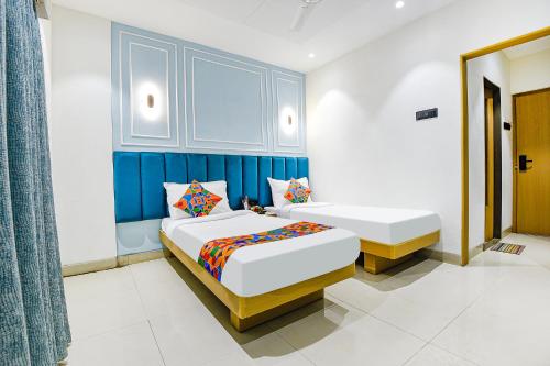 a bedroom with two beds and a blue wall at Hotel Supreme - 700M From Vasco Da Gama Railway Station in Marmagao