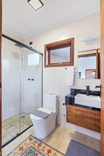 a bathroom with a toilet and a sink and a shower at Altos da Mantiqueira Chalés -Grupo Vertentes in Santo Antônio do Pinhal