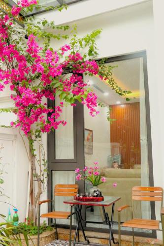 a table and chairs with pink flowers in a room at TH Villa, Vinhome Ocean Park, Hanoi in Hanoi