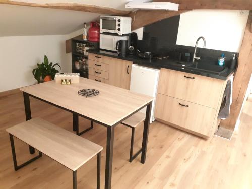 une petite cuisine avec une table et un évier dans l'établissement Appartement chez l'habitant, à Gragnague