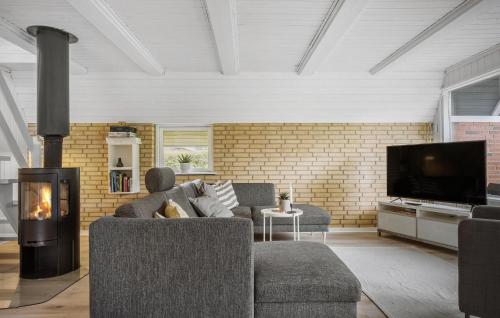 Una sala de estar con un sofá y una chimenea. en 3 Bedroom Stunning Home In Højslev, en Højslev