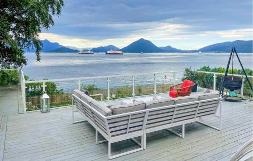 a swinging bench on a deck with a view of the water at Pet Friendly Home In Mauseidvåg in Holen