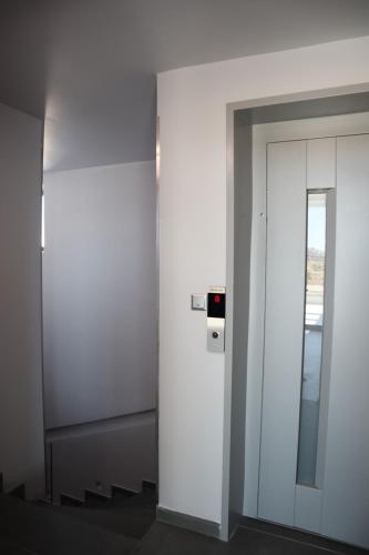 an elevator in a building with a glass door at Golden Sand Suites 2 in Anavissos