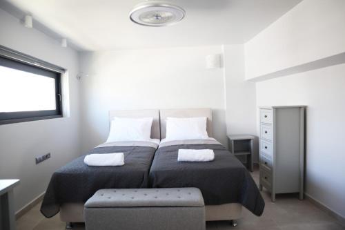 a bedroom with two beds and a window at Golden Sand Suites 2 in Anavissos