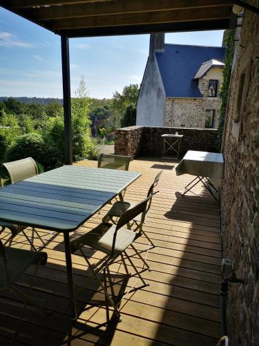 un patio avec une table et des chaises sur une terrasse dans l'établissement Le Chant des Oiseaux, à Saint-Pair-sur-Mer