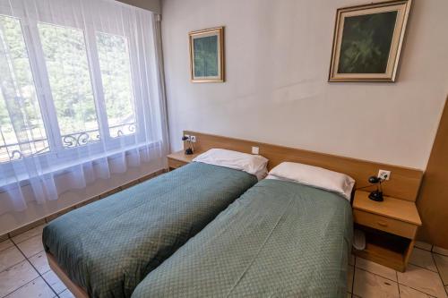 a bedroom with two beds next to a window at Albergo Stazione in Bodio