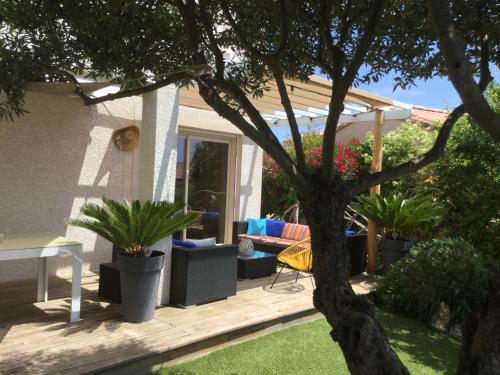 une terrasse avec des plantes en pot et un arbre dans l'établissement Maison à la Palme, à Lapalme