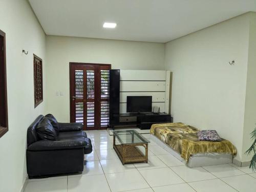 a living room with a bed and a couch at Paraíso de Genipabu in Extremóz