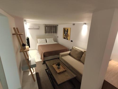 a small bedroom with a bed and a couch at Kali lux duplex in Kallithea Halkidikis