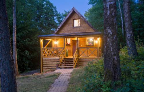 a tiny house in the woods with lights on at 2 Bedroom Awesome Home In Bobolice in Bobolice
