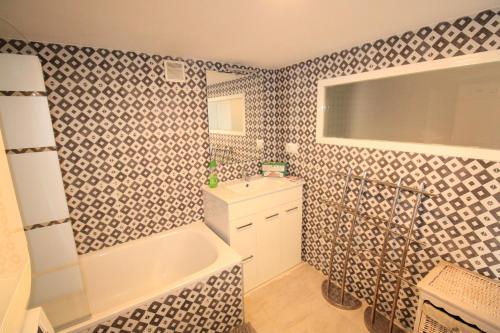 Un baño con bañera blanca, lavabo y bañera. en Villa Betty, en Denia