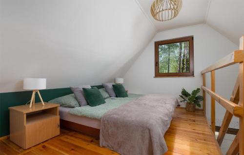 a bedroom with a bed with green pillows at 2 Bedroom Awesome Home In Bobolice in Bobolice