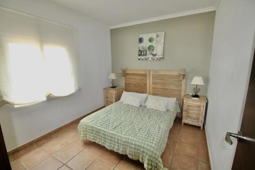 Un dormitorio con una cama y dos mesitas de noche con lámparas. en Villa Betty, en Denia
