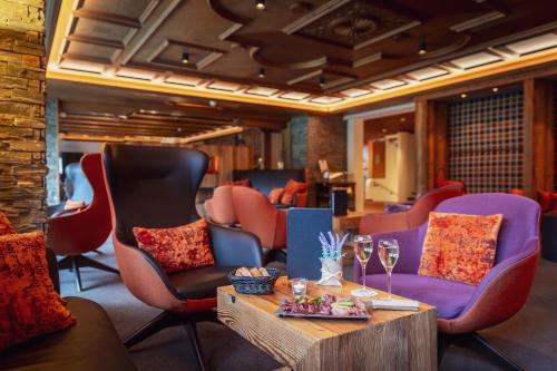 a lobby with chairs and a table with wine glasses at Sunstar Hotel Klosters in Klosters