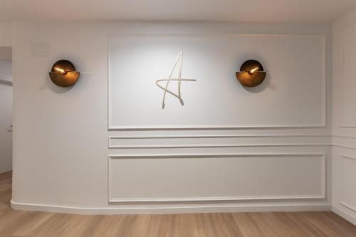 a white wall with two clocks on it at Arenal Suites Bilbao in Bilbao