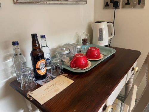 a table with a tray of food and bottles of beer at The Fox in Chipping Norton