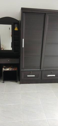 a bathroom with a black dresser and a mirror at Sathitsit Mansion in Bangkok
